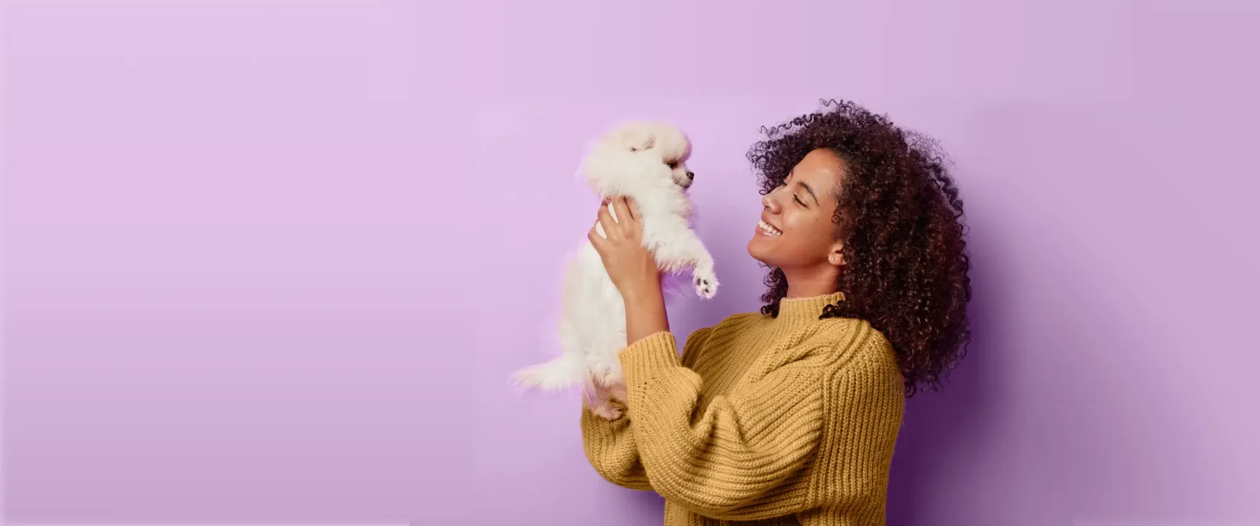 Woman holding a fluffy white puppy